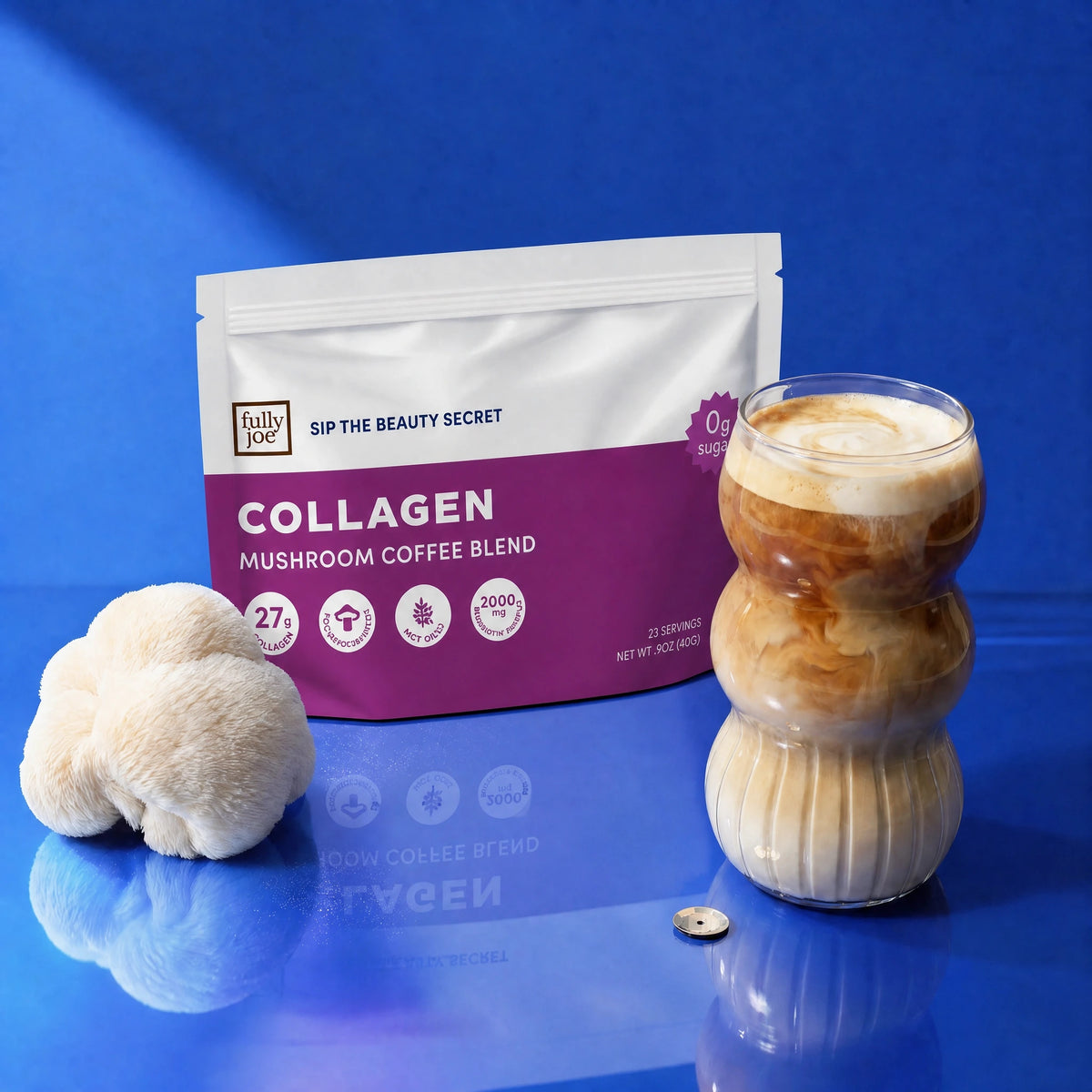 A bag of Fully Nutrition Collagen Mushroom Coffee, a creamy glass of mushroom-infused coffee, a fresh lion’s mane mushroom, and a shining coin rest on a glossy blue surface—creating an inviting scene that highlights the age-defying benefits and brain-boosting power in every cup from Fully Nutrition.