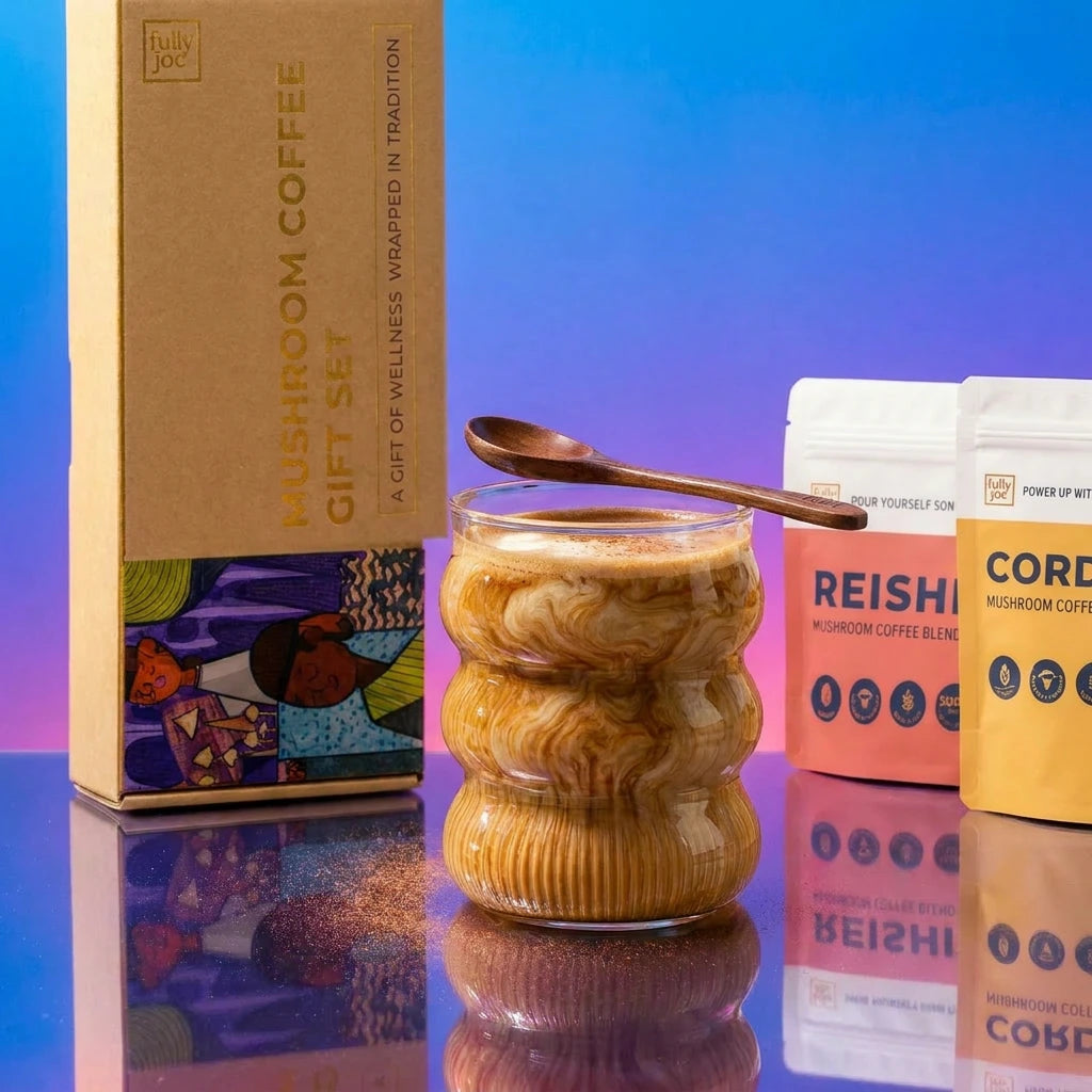 A wavy glass of Fully Nutrition Mushroom Coffee with a wooden spoon on top sits beside the Mushroom Coffee Gift Set box and two coffee blend pouches, all displayed on a reflective surface with a gradient background.