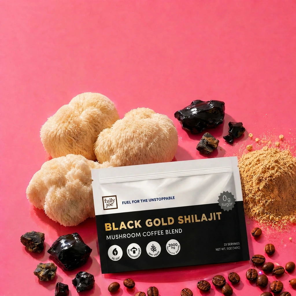 A packet of Fully Nutrition Shilajit Coffee by Fully Nutrition is surrounded by mushrooms, coffee beans, black shilajit resin pieces, and a small pile of powder on a pink background.