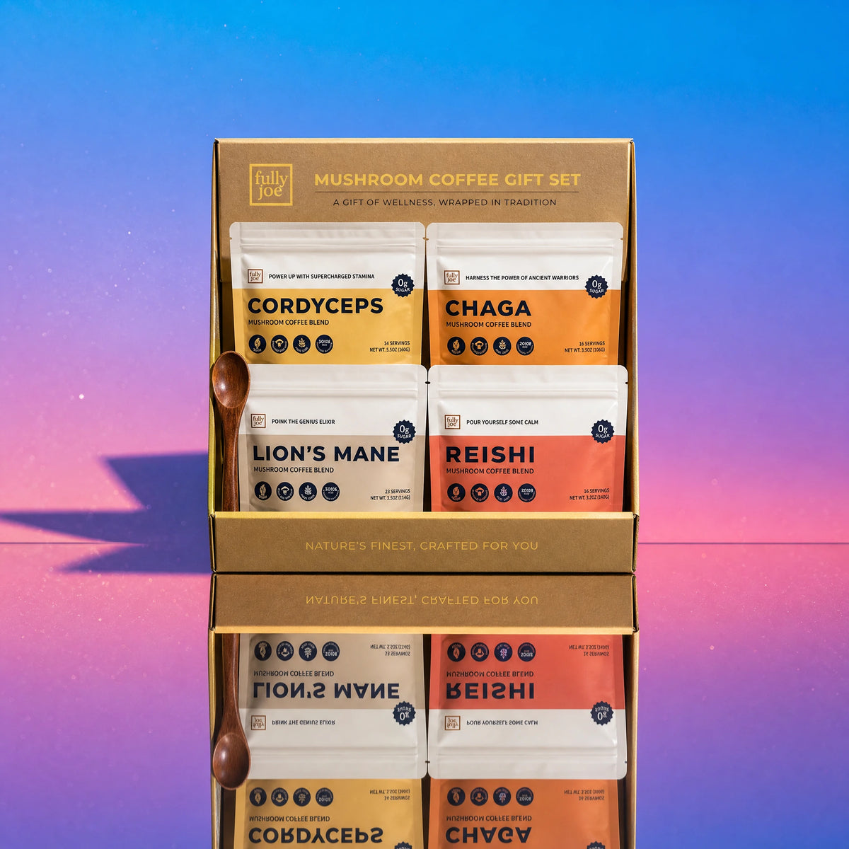The Fully Nutrition Mushroom Coffee Gift Set features four varieties of mushroom coffee packets and a small wooden spoon, elegantly arranged in a gift box and displayed on a reflective surface with a pink and blue gradient backdrop.